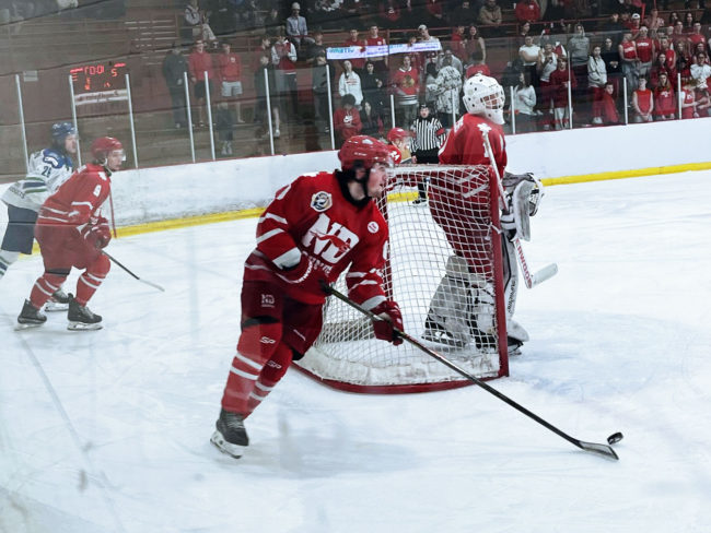 Notre Dame Hounds Hockey game, player with the puck rounding the net to start a play